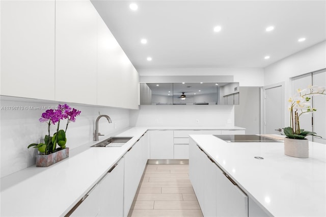 kitchen with light countertops, modern cabinets, a sink, and white cabinets