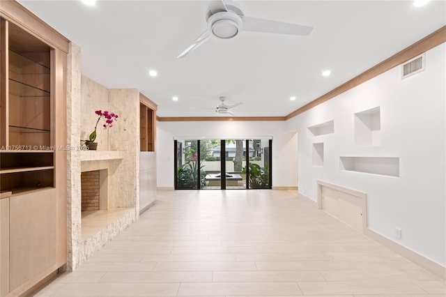 unfurnished living room with baseboards, visible vents, a ceiling fan, built in features, and a fireplace