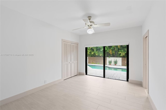 spare room with light wood-style flooring, baseboards, and a ceiling fan