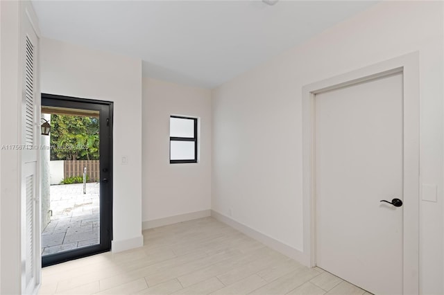 empty room featuring baseboards and light wood-style floors