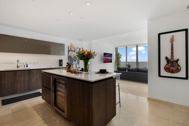 kitchen featuring dark brown cabinetry, modern cabinets, a kitchen island, a breakfast bar, and light countertops