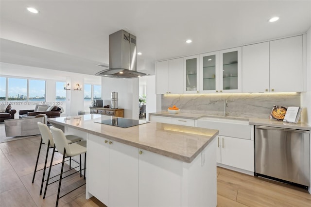 kitchen featuring a center island, black electric stovetop, a sink, island range hood, and dishwasher