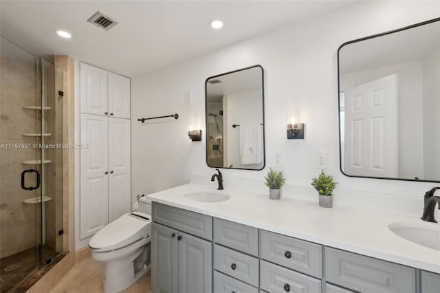 bathroom with visible vents, a sink, and a shower stall