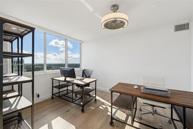 office area with baseboards, visible vents, and light wood finished floors