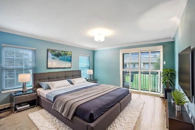 bedroom featuring baseboards, crown molding, and wood finished floors