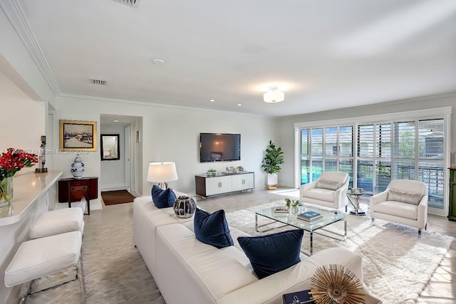 living room featuring baseboards, visible vents, and crown molding