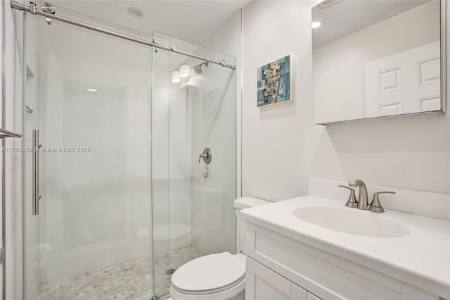 bathroom with a stall shower, vanity, and toilet