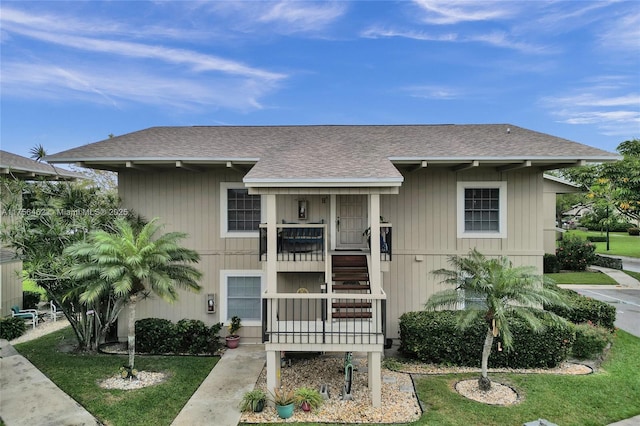 view of front of house featuring a front lawn and roof with shingles