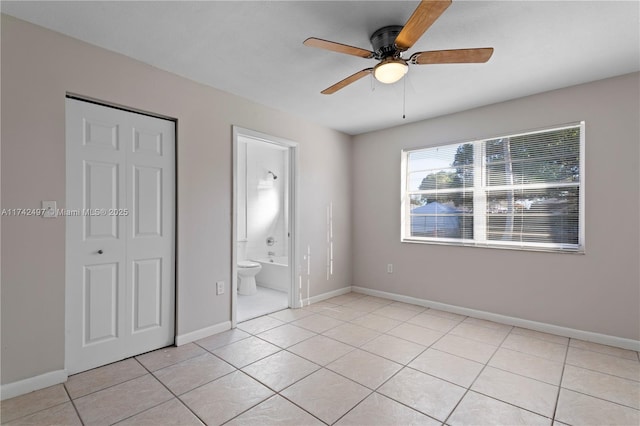 unfurnished bedroom featuring light tile patterned floors, ceiling fan, baseboards, and a closet