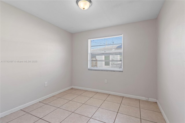 empty room featuring light tile patterned floors and baseboards