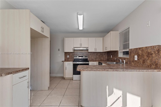 kitchen with light tile patterned flooring, a sink, a peninsula, under cabinet range hood, and stainless steel electric range