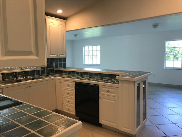 kitchen featuring black dishwasher, plenty of natural light, tile countertops, and a peninsula