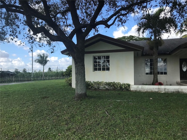 view of home's exterior with a lawn and stucco siding