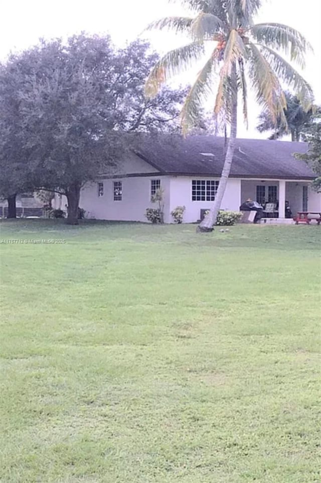 exterior space with a lawn and stucco siding