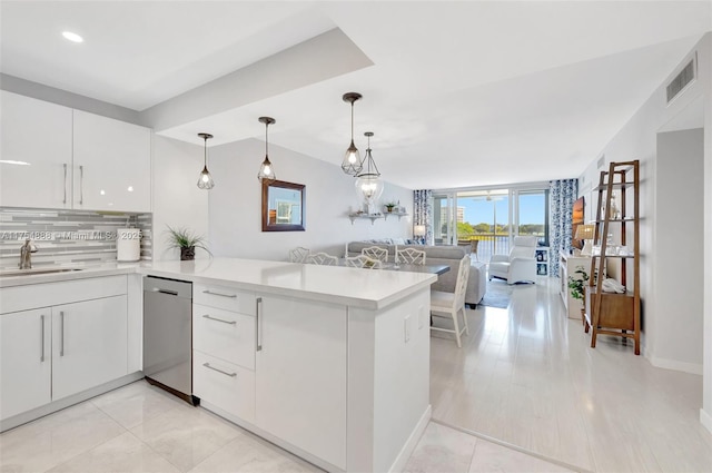 kitchen featuring visible vents, backsplash, open floor plan, a sink, and dishwasher