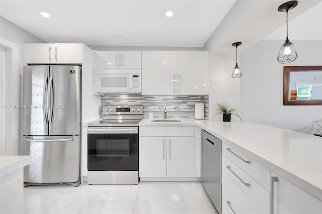 kitchen featuring stainless steel appliances, tasteful backsplash, light countertops, white cabinets, and a sink