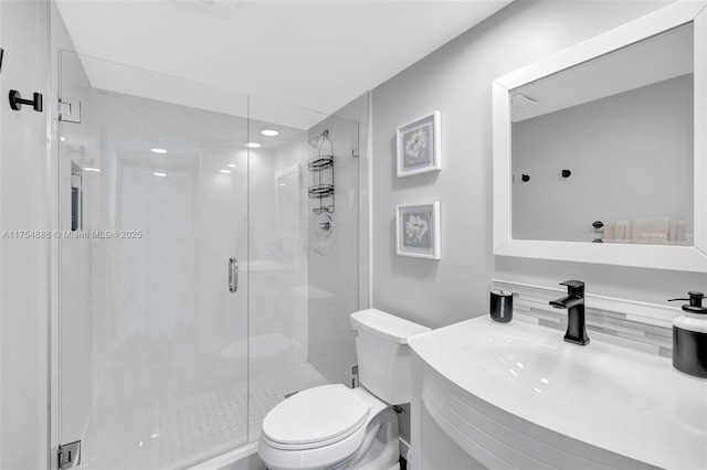 full bath featuring a stall shower, vanity, and toilet