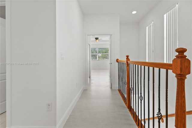 hallway with recessed lighting, an upstairs landing, and baseboards