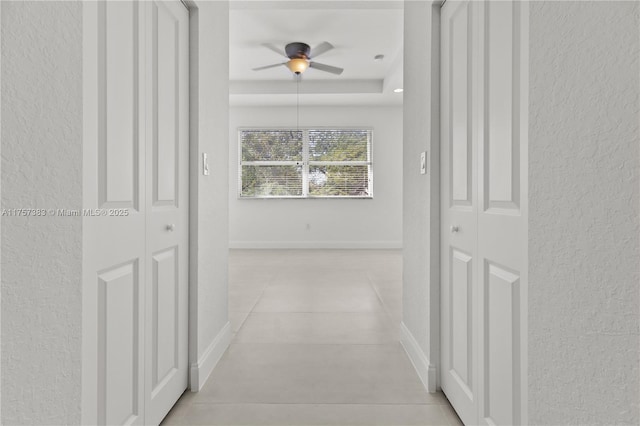 corridor with tile patterned flooring and baseboards