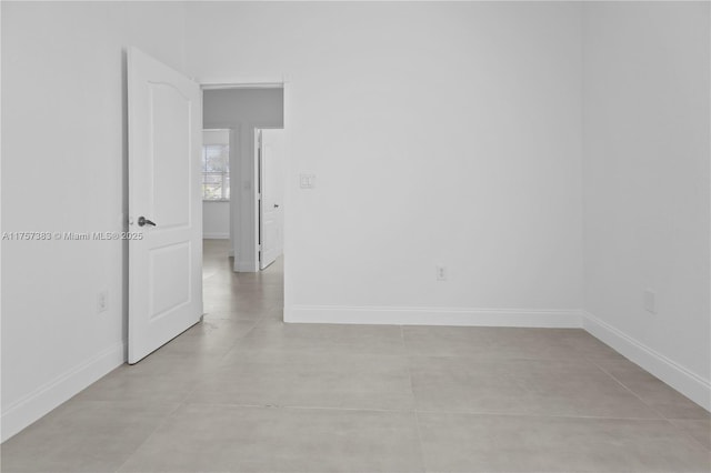 unfurnished room with baseboards