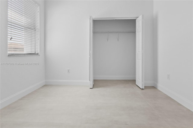 unfurnished bedroom featuring a closet and baseboards