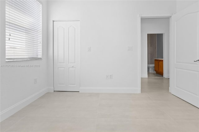 unfurnished room with baseboards and light tile patterned floors