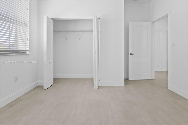 unfurnished bedroom featuring a closet and baseboards