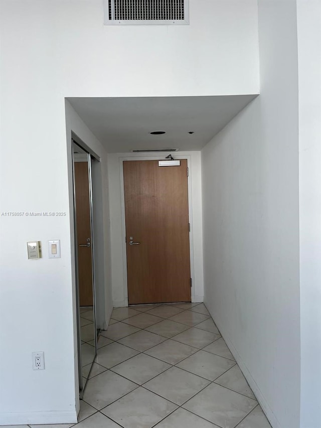 corridor featuring light tile patterned floors and visible vents