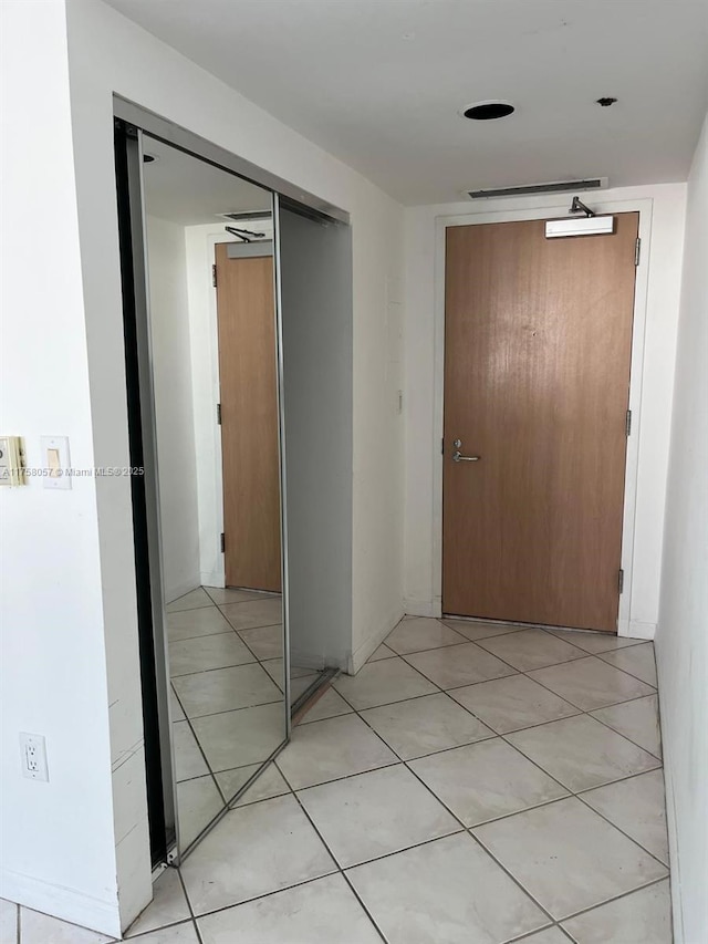 hall featuring light tile patterned floors