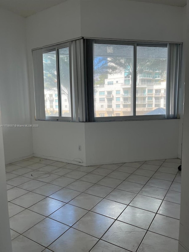 spare room featuring light tile patterned floors and a wealth of natural light