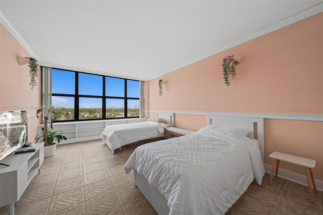 bedroom with ornamental molding and baseboards