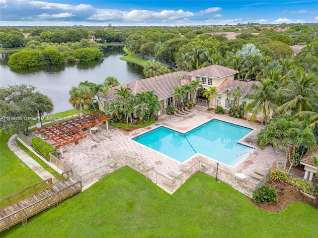 pool featuring a patio area, a water view, fence, and a lawn