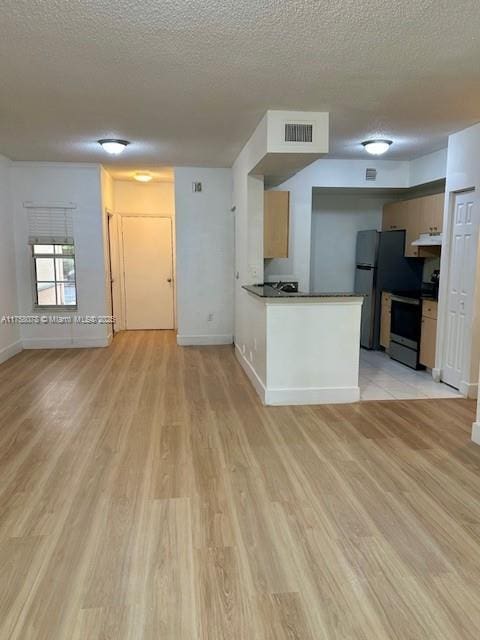 kitchen with under cabinet range hood, electric range, visible vents, and light wood-style floors