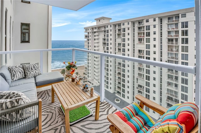 balcony featuring a water view, outdoor lounge area, and a view of the beach