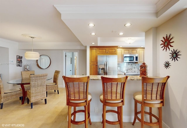 kitchen with recessed lighting, stainless steel appliances, a peninsula, ornamental molding, and decorative backsplash