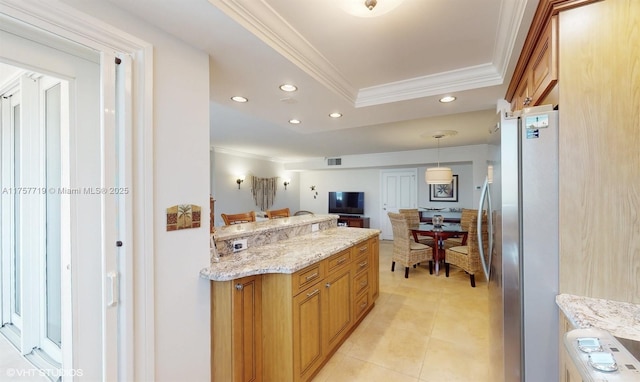 kitchen with brown cabinets, freestanding refrigerator, light tile patterned flooring, crown molding, and recessed lighting