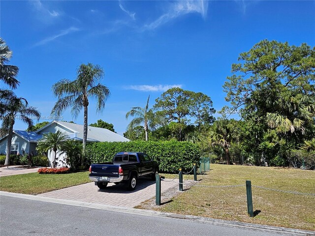 8904 SW Fishermans Wharf Dr, Stuart, FL 34997 - view of property hidden behind natural elements featuring decorative driveway and a front yard