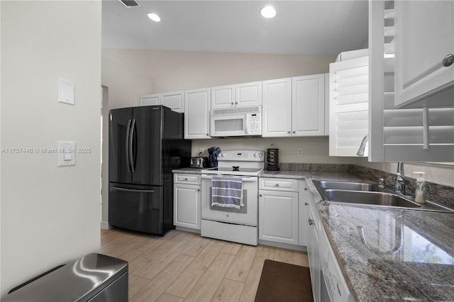 8904 SW Fishermans Wharf Dr, Stuart, FL 34997 - kitchen with white appliances, white cabinetry, light wood-type flooring, lofted ceiling, and a sink