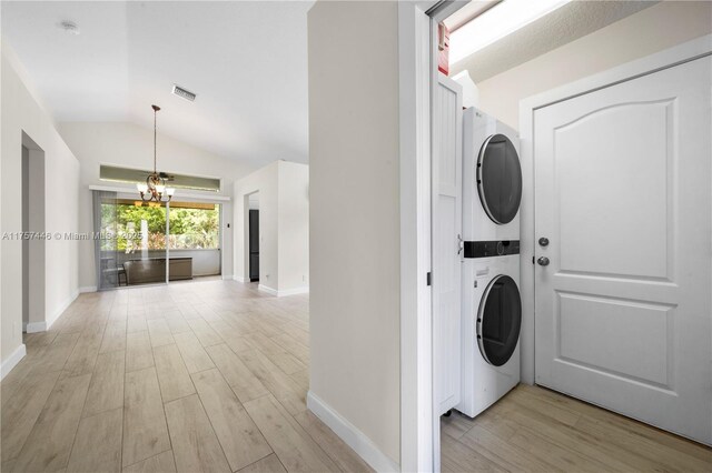 8904 SW Fishermans Wharf Dr, Stuart, FL 34997 - laundry area featuring stacked washer / drying machine, light wood-style floors, a chandelier, and baseboards