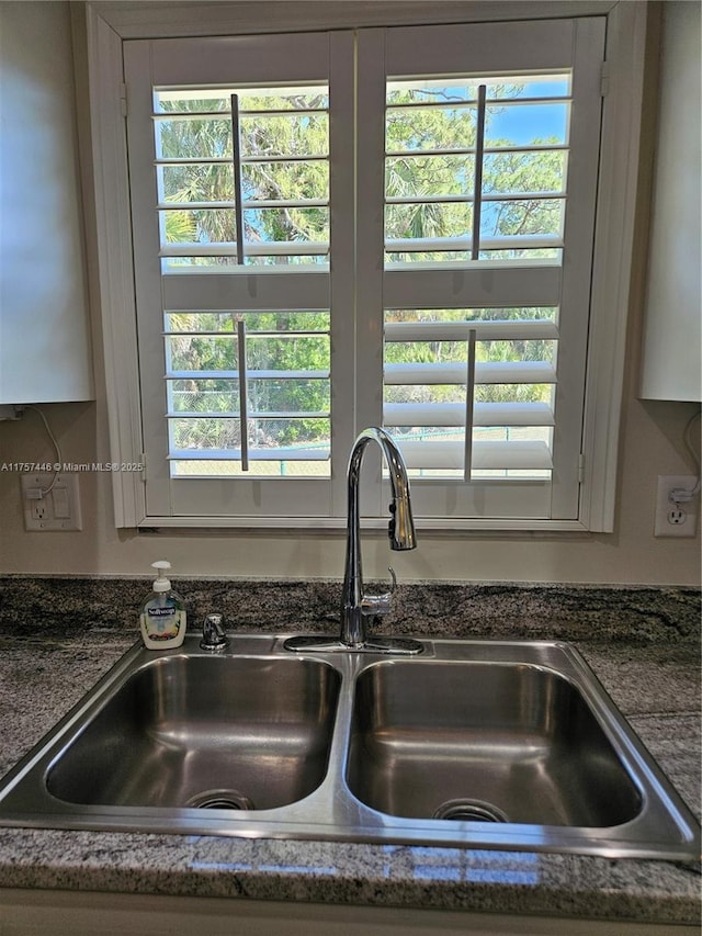 8904 SW Fishermans Wharf Dr, Stuart, FL 34997 - kitchen view of a sink and dark stone countertops