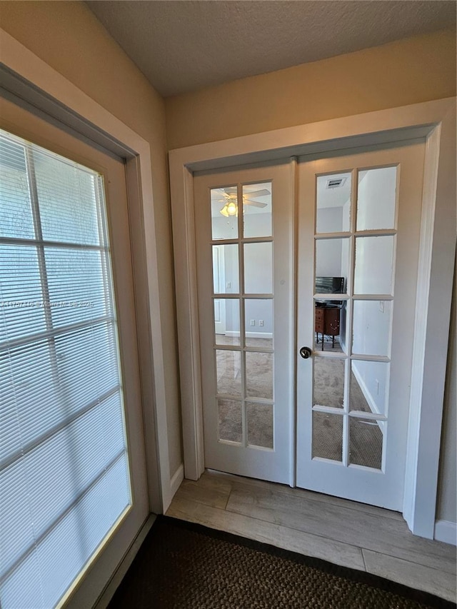 8904 SW Fishermans Wharf Dr, Stuart, FL 34997 - doorway to outside featuring french doors, plenty of natural light, and light wood-style flooring