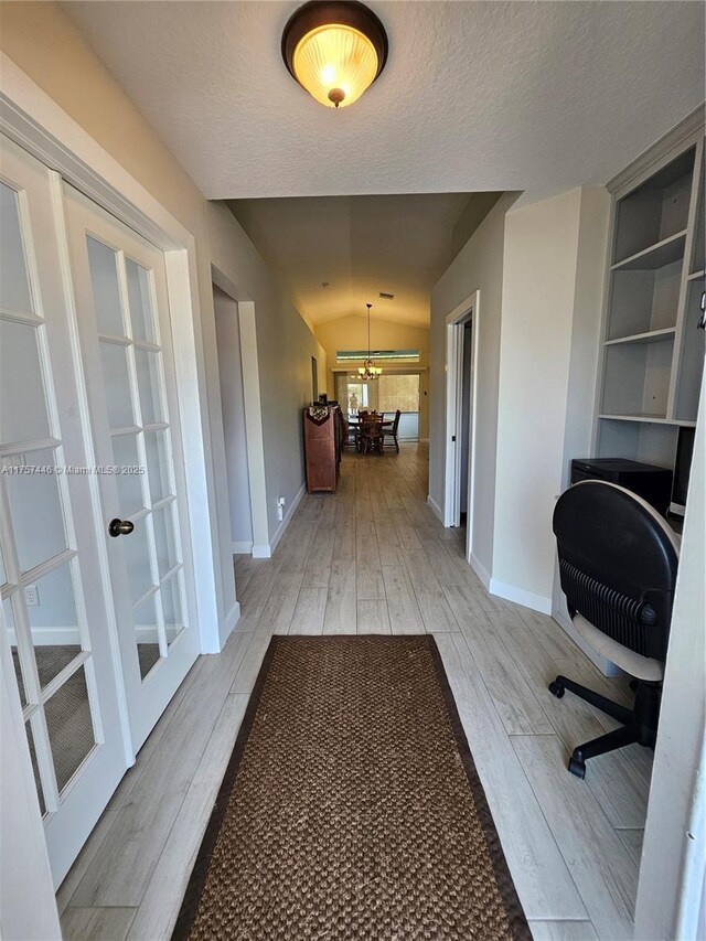 8904 SW Fishermans Wharf Dr, Stuart, FL 34997 - unfurnished office with french doors, baseboards, light wood-style floors, vaulted ceiling, and a textured ceiling