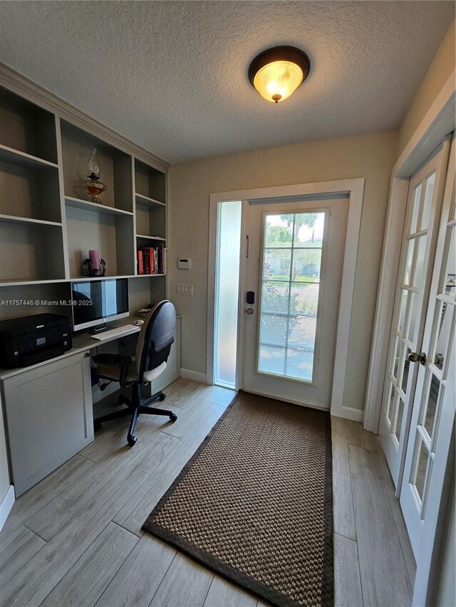 8904 SW Fishermans Wharf Dr, Stuart, FL 34997 - office featuring light wood-type flooring, a textured ceiling, baseboards, and french doors
