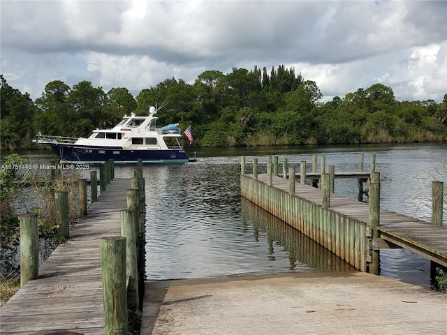 8904 SW Fishermans Wharf Dr, Stuart, FL 34997 - dock area with a boat ramp, a water view, and a view of trees