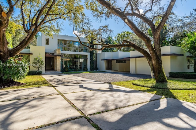 view of front of property featuring stone siding, concrete driveway, an attached garage, and stucco siding