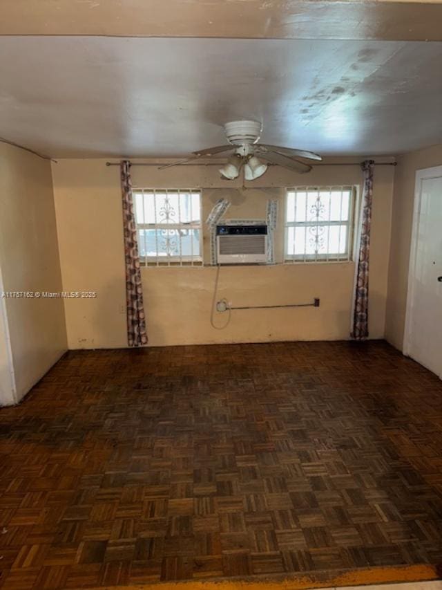 unfurnished room with a wall unit AC and ceiling fan