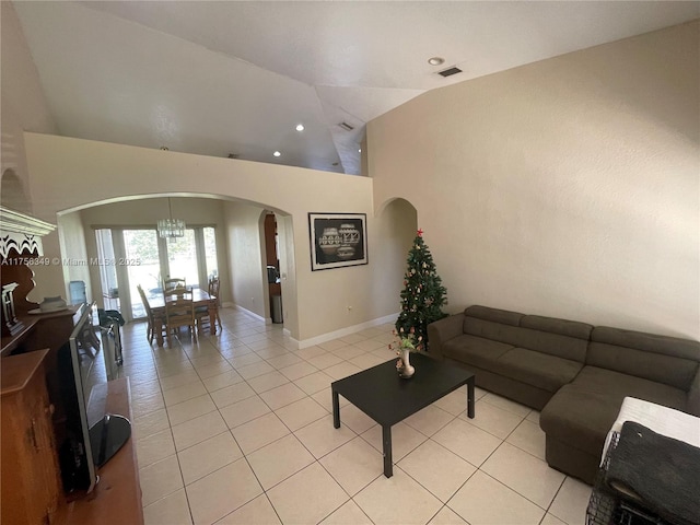 living room with visible vents, baseboards, light tile patterned floors, arched walkways, and high vaulted ceiling