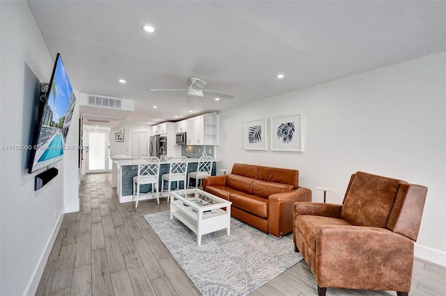 living room with recessed lighting, visible vents, light wood-style floors, a ceiling fan, and baseboards