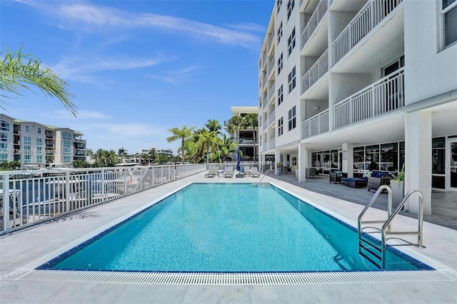 community pool with a patio area and fence