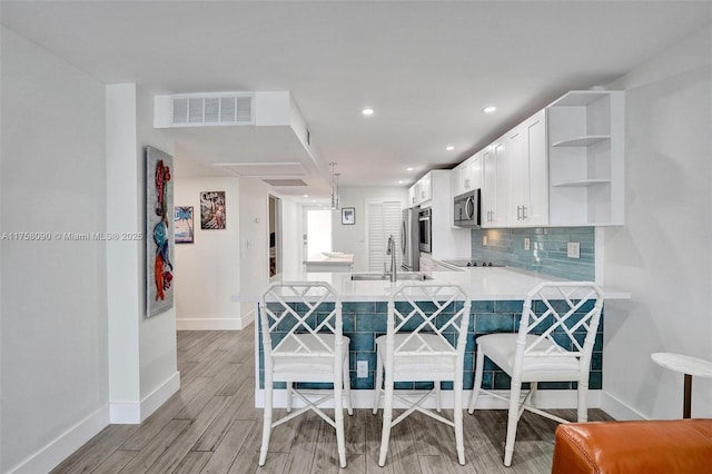 kitchen featuring a sink, visible vents, decorative backsplash, open shelves, and stainless steel microwave